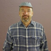 Man in a gray cap with a salt and pepper mustache and goatee